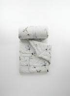 Floral-patterned quilt and pillow on a plain background