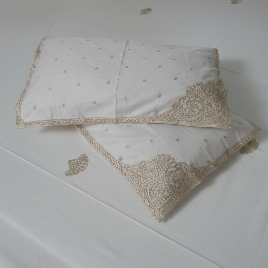Two embroidered pillows on a white surface