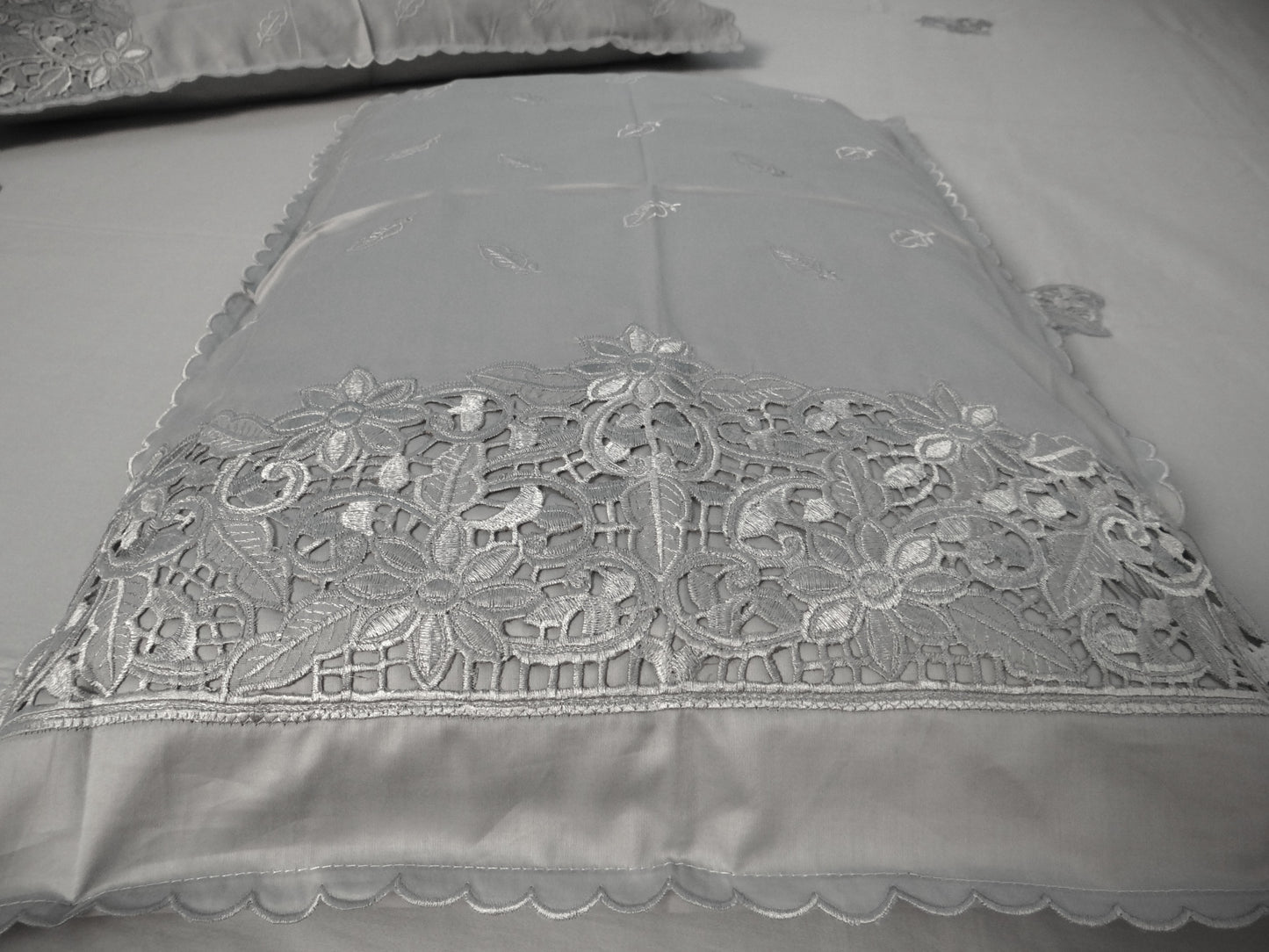 Gray lace fabric with intricate patterns on a plain background