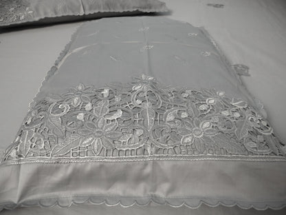 Gray lace fabric with intricate patterns on a plain background