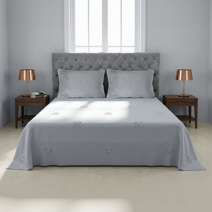 Gray upholstered bed with matching headboard and side tables in a bedroom setting.
