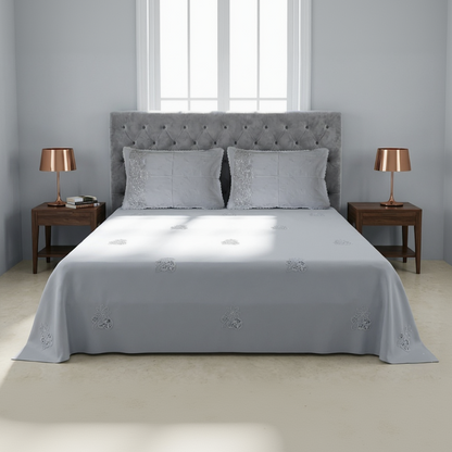 Gray upholstered bed with matching headboard and side tables in a bedroom setting.