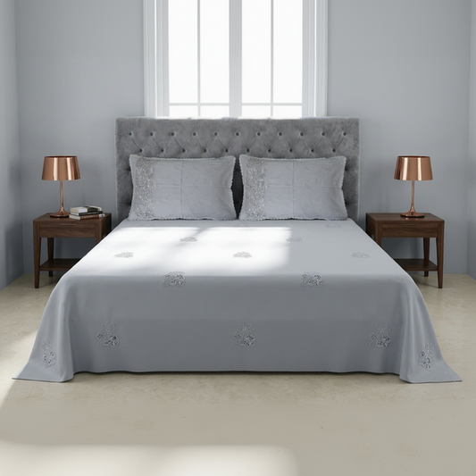 Gray upholstered bed with matching headboard and side tables in a bedroom setting.